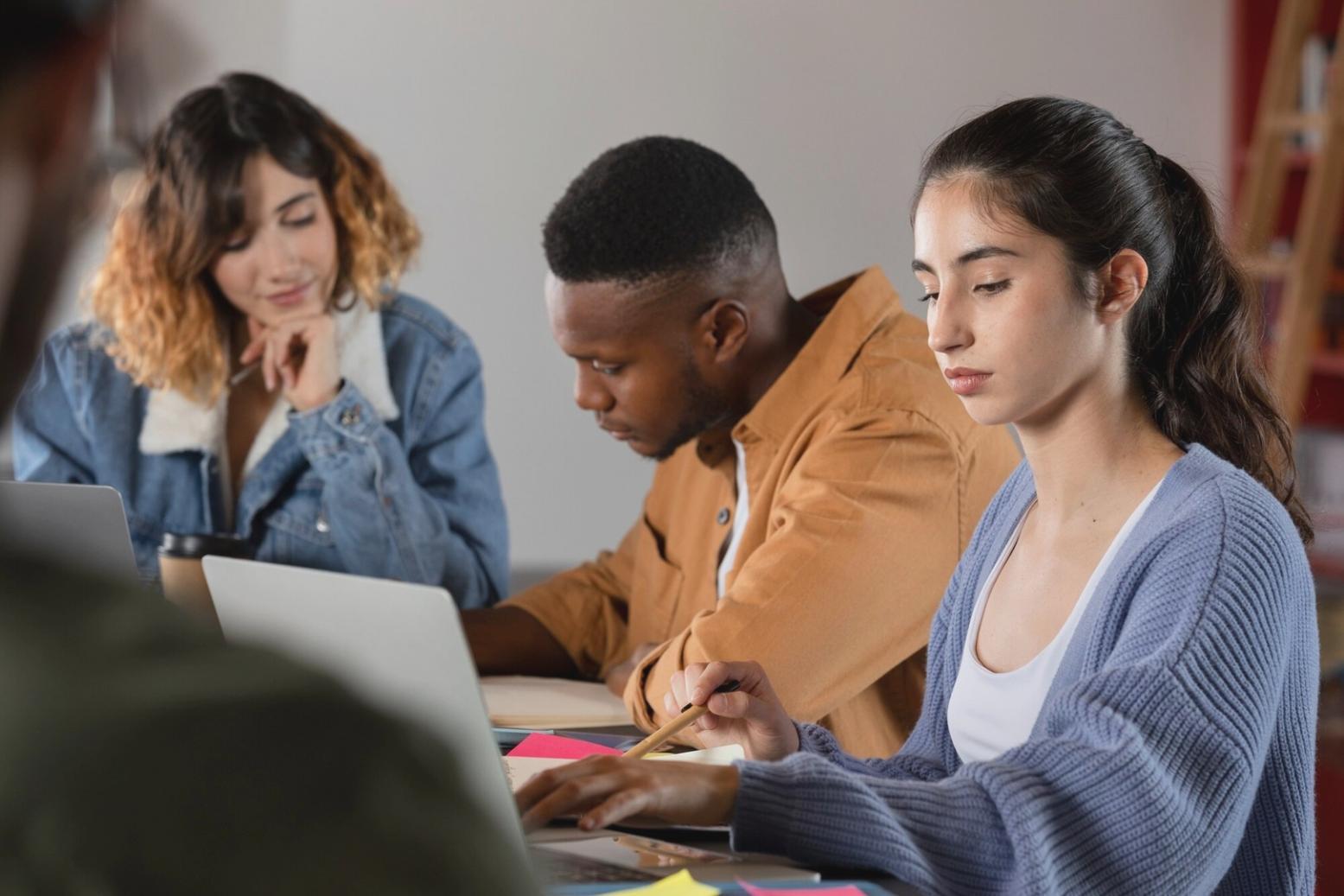Estudiantes trabajando con análisis financiero en ordenadores